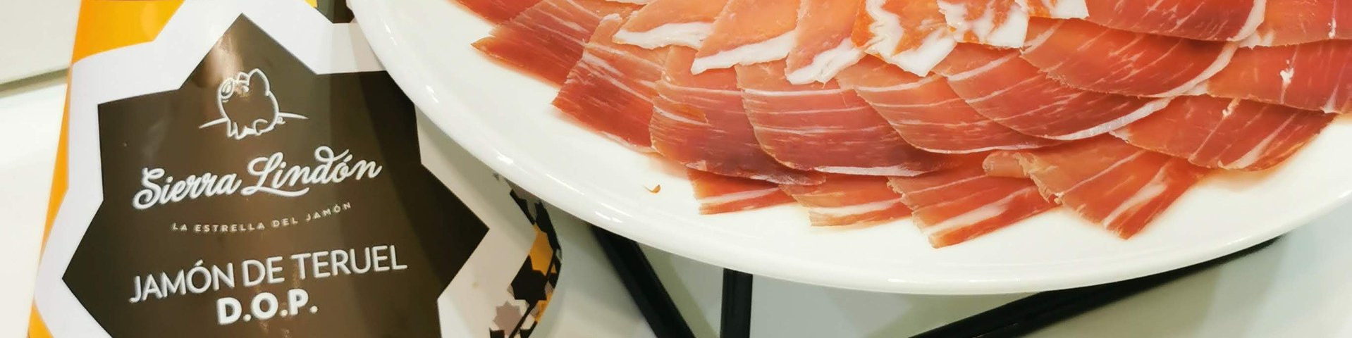 Plato de Jamón de Teruel DOP cortado a cuchillo junto a la vitola Sierra Lindón